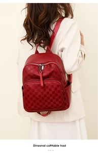 Detail of red checkerboard embossed leather backpack with matching tassel decor