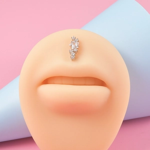 Gros plan d'un piercing de lèvre en acier avec zircons blancs sur un modèle de lèvre