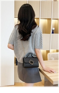 Primer plano de un mini bolso de cadena en cuero repujado negro estilo bandolera