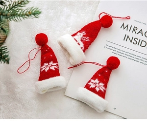 Detailaufnahme kleiner Strick-Weihnachtsmützen mit Schneeflockenmuster als Weihnachtsdeko