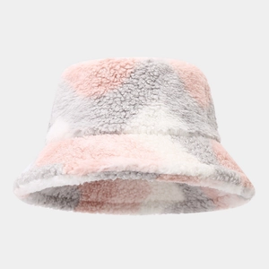 Gros plan du patchwork en laine d'agneau rose, gris et blanc sur un bob d'hiver épais