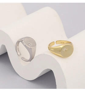 Close-up of gold and silver S925 rings featuring a sparkling geometric star stone