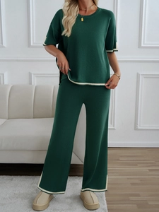 Detail view of dark green knit two-piece set with contrasting beige trim and wide-leg pants