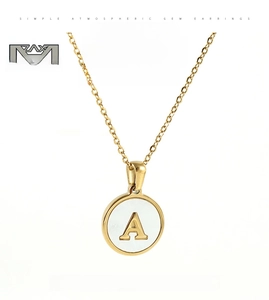 Detail of 18K gold letter A pendant with natural shell inlay on delicate chain