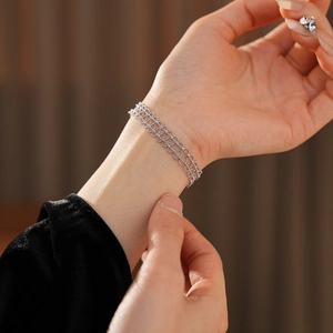 Detail of silver beaded bracelet with lace-like hollow texture on model's wrist