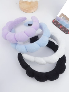 Close-up of thick sponge headbands in purple, blue, white, and black terry cloth fabric