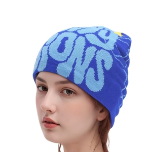 Detail view of royal blue knit beanie featuring light blue jacquard letter pattern