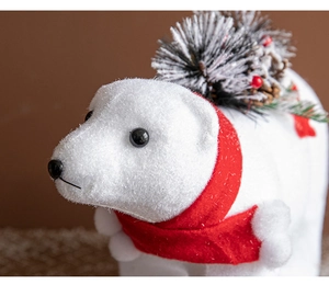 Detailed macro view of white flocked polar bear figurine with red scarf and pine cone