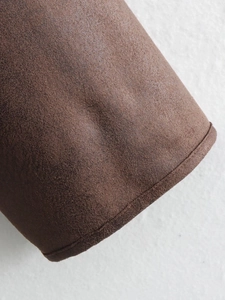 Detail of brown faux suede jacket showing precision stitching and fabric texture