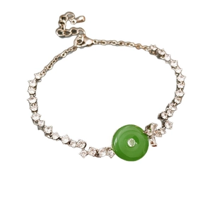 Silver bracelet with green chalcedony pendant and cubic zirconia bow on white background