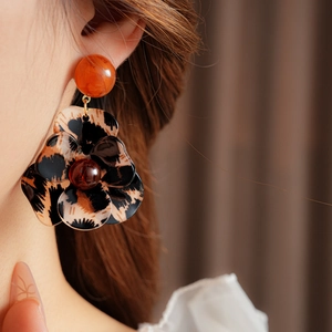 Detailed view of leopard print flower earrings with resin petals and silver needle studs
