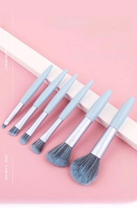 Detail showing 7-piece light blue makeup brush set with gradient blue synthetic bristles