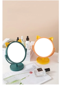 Detail of cute cat ear makeup mirrors on desk showing rotating frame and sturdy round base