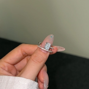 Close-up of S925 sterling silver emerald cut ring set with micro-paved diamonds on hand