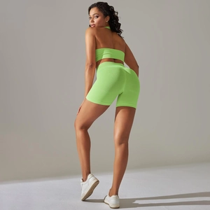 Detail of neon green ribbed seamless yoga set showing cross back top and high waist shorts