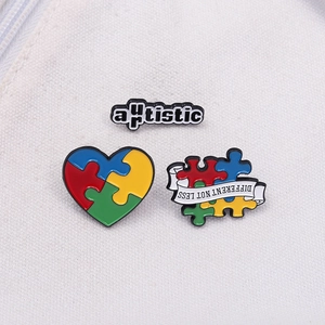 Three-piece colorful puzzle heart enamel pin set with Different Not Less message