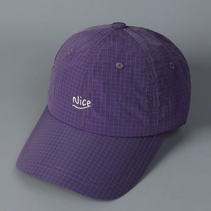 Close-up of purple plaid baseball cap featuring white Nice embroidery and fine checkered fabric