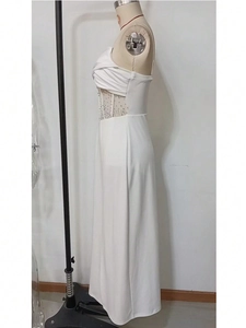Detail of white evening gown featuring rhinestone embellishments and sheer mesh waist