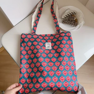 Close-up of vintage Indian print cotton tote bag with floral pattern and woven handles