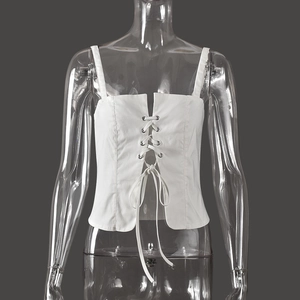 Detalle frontal de top corto tipo corsé blanco con cordones ajustables y costuras