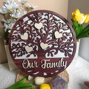 Detail of a round wooden family tree plaque with heart charms and Our Family text