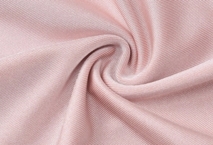 Macro shot of pink ribbed knit fabric with soft texture and elegant draped folds