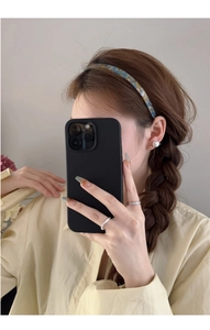 Détail d'un serre-tête floral en acétate bleu et jaune porté par un mannequin pour un selfie