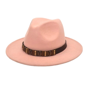 Detail of pink wool fedora with brown leather band and golden cylindrical studs