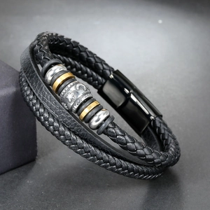 Detail of woven leather bracelet featuring stainless steel star and moon engraved beads