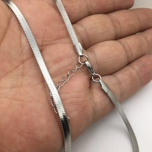 Detailed macro view of silver titanium steel flat snake chain with lobster clasp and extender
