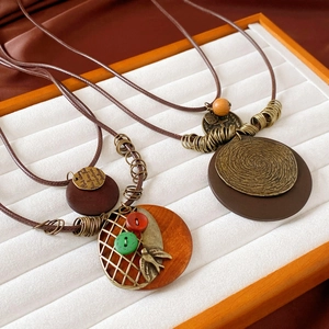 Vintage long tassel necklace with resin beads and leaf pendant on white velvet tray
