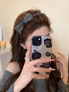 Close-up of a grey polka dot bow headband on a model showing high-crown hair styling