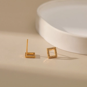 Detailed close-up of hollow square gold-plated stud earrings with pavé-set clear crystals