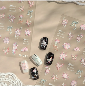 Detail of floral and butterfly nail stickers with bow designs on black and white tips