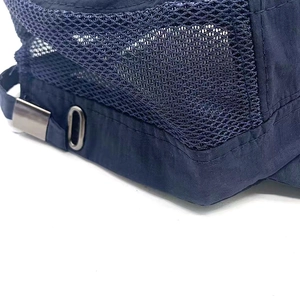 Detail of navy blue mesh cap featuring breathable honeycomb fabric and metal buckle
