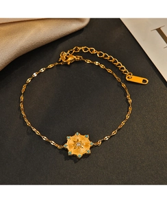 Detail of 14K gold plated octagon star bracelet with blue gems and a clear zircon