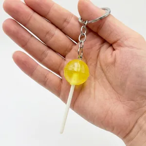 Detailed close-up of a translucent lemon yellow lollipop keychain with silver metal ring
