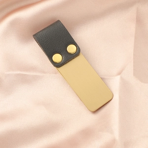 Dettaglio clip per penna vintage in acciaio inossidabile con pelle grigia e rivetti dorati