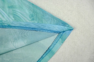 Detail of teal mesh fabric showing high-quality double-stitched hem and fine texture