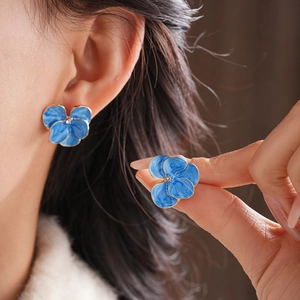 Vue détaillée des boucles d'oreilles pensée vintage avec pétales bleus et bordure dorée