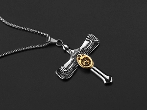Macro detail of silver winged Ankh cross pendant with golden scarab emblem on box chain