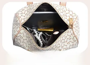 Top view of spacious interior of beige patterned Boston bag holding iPad and makeup