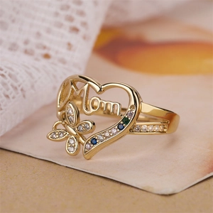 Close-up of golden heart ring with Mom text, crystal butterfly and colorful gemstones