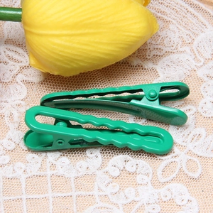 Detail of two green macaron hair clips on lace fabric with a decorative yellow tulip