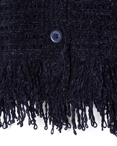 Dettaglio del cardigan in maglia blu scuro con orlo a frange e trama dei bottoni tondi