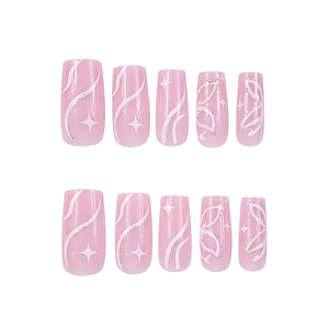 Detailed view of pink press-on nails with white stars, butterfly motifs, and tiny rhinestones
