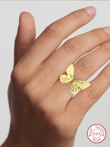 Close-up of golden butterfly S925 silver adjustable ring worn on a model finger