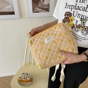 Detail of yellow and pink quilted floral makeup bag with soft textured grid pattern