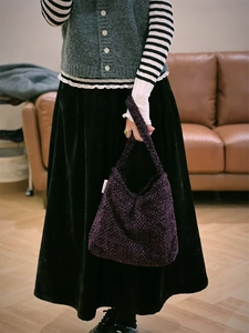 Dettaglio della borsa tote in tweed viola intrecciato con etichetta laterale