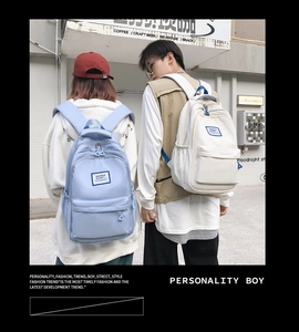 Outdoor lifestyle shot of two teenagers wearing light blue and beige school backpacks